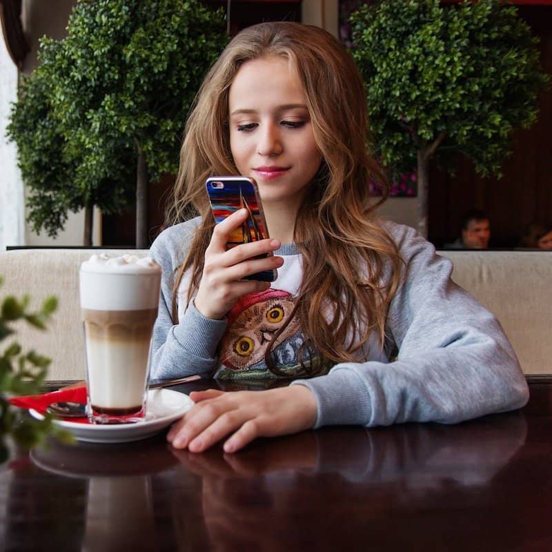 Ragazza che legge un menu digitale su smartphone