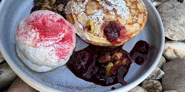150g homemade pancakes with cream cheese cream, forest fruits and pistachios glazed in maple sirup 